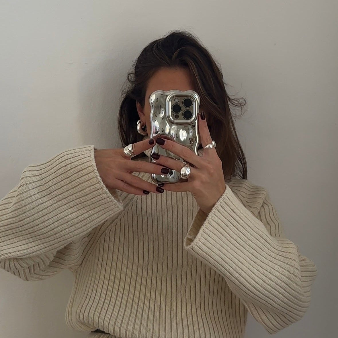 bold silver rings worn on brunette woman in mirror selfie