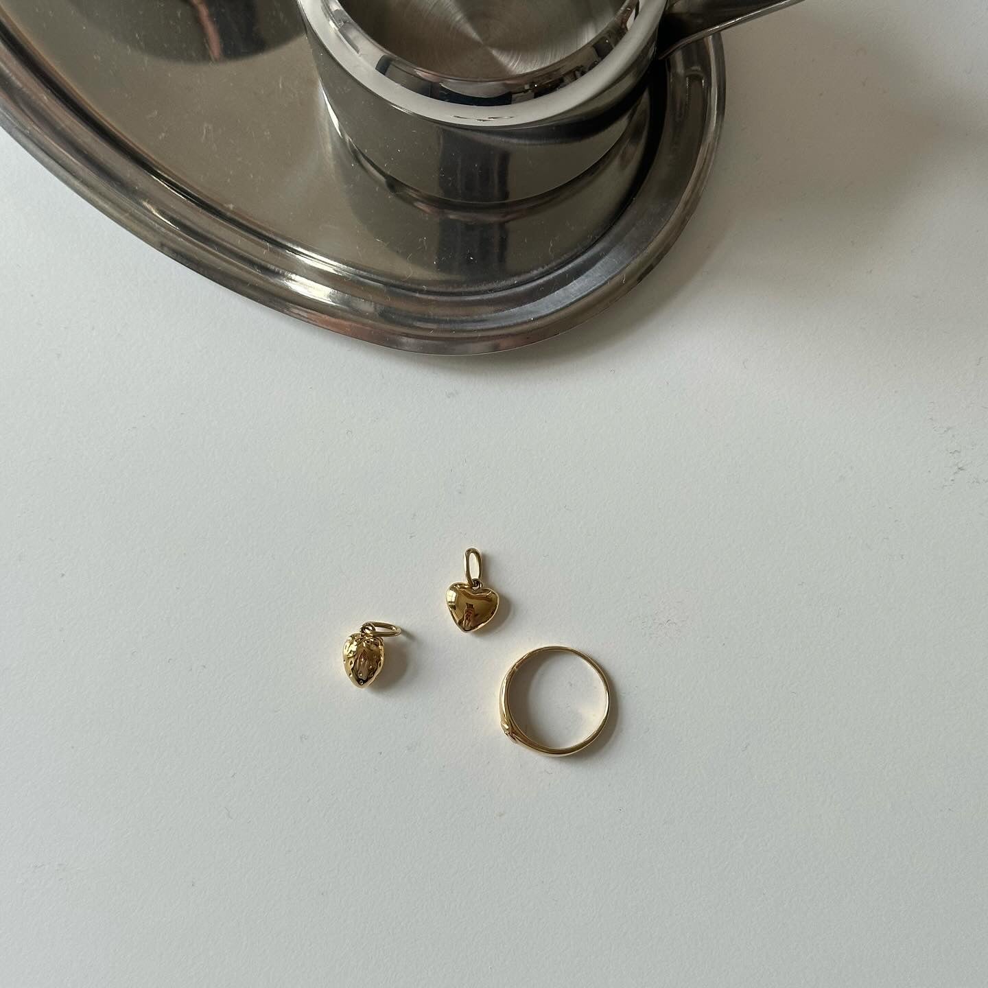 heart charm, strawberry charm and Gigi ring in gold on white table setting