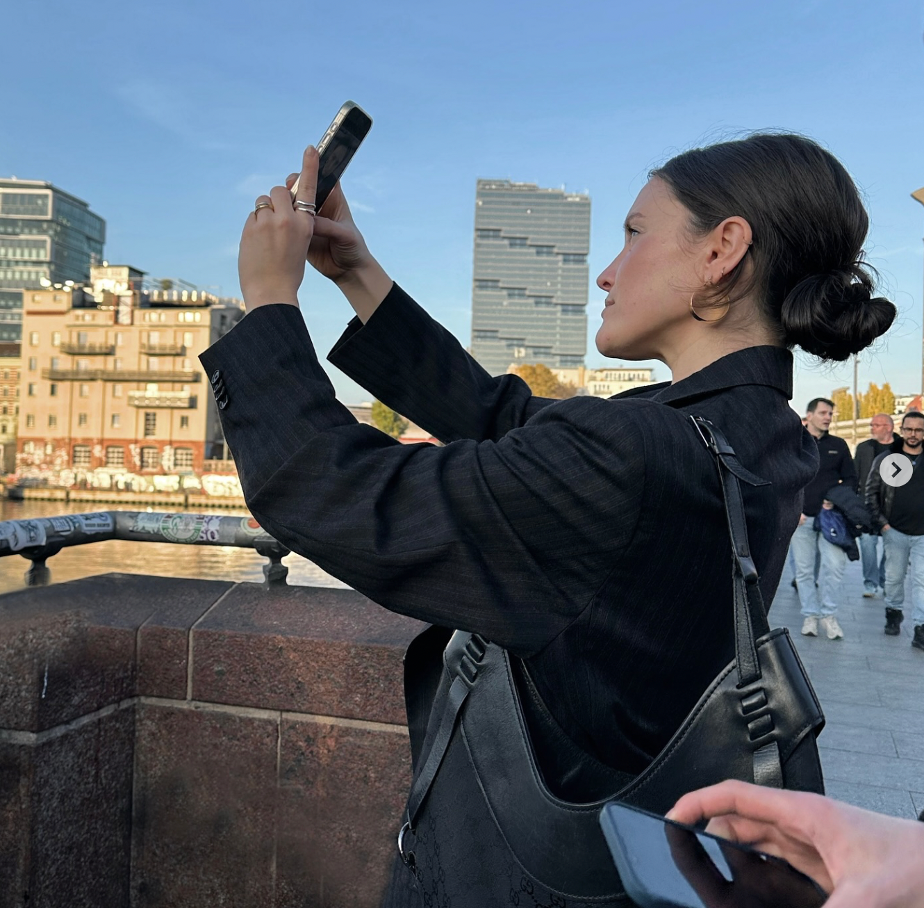 Mädchen, das Bella-Reifen in Gold auf den Straßen von Berlin trägt und ein Selfie macht