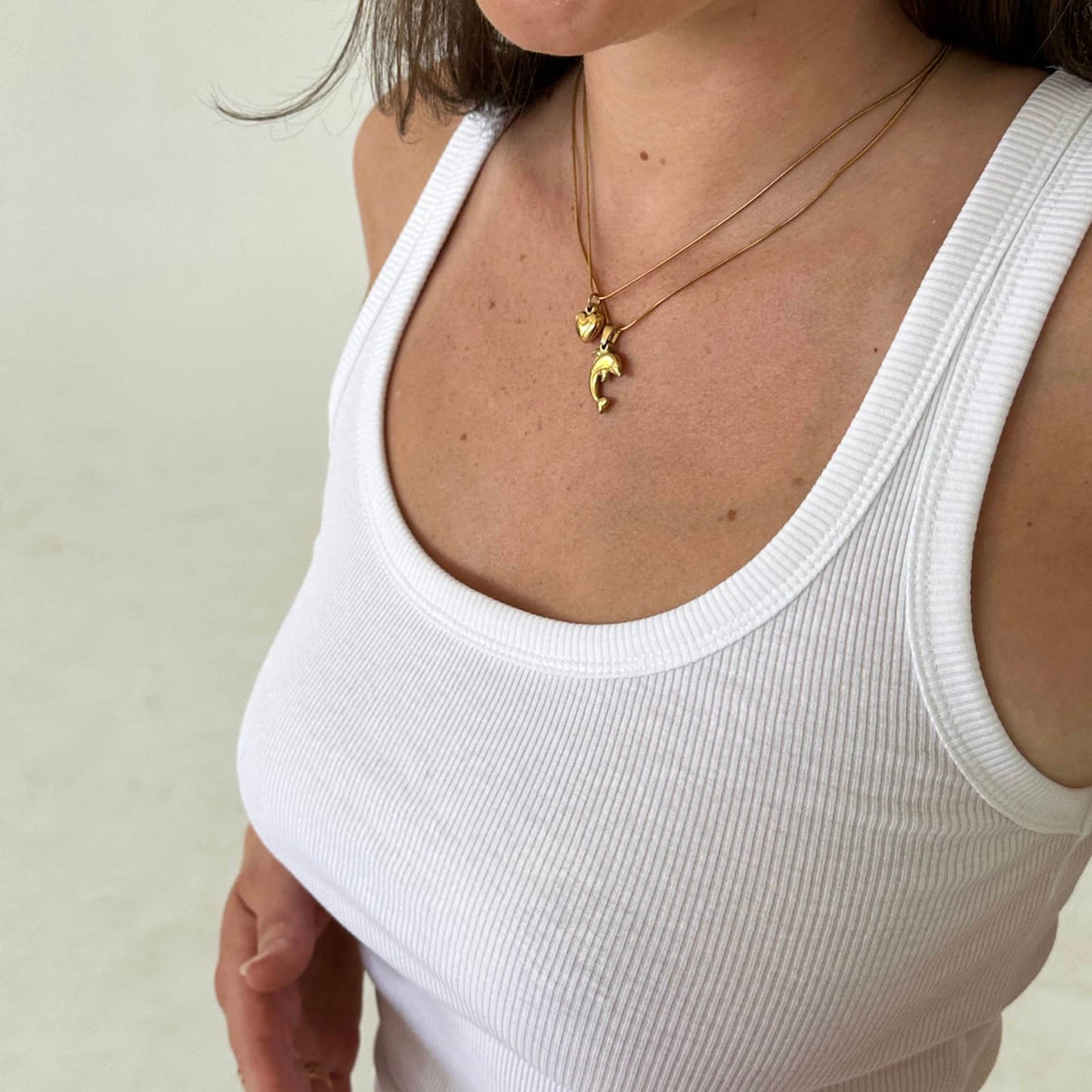 Dolphin Charm Delfin Anhänger getragen an Frau mit Heart of Gold Anhänger