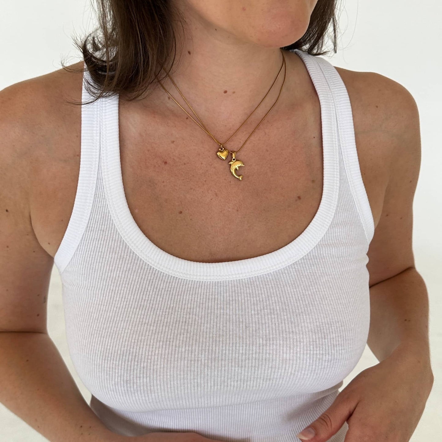 Dolphin Charm Delfin Anhänger getragen mit Heart of Gold Halskette an Frau