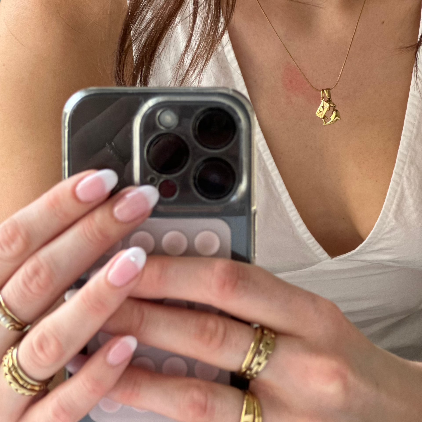mirror photo seeing the phone holding and wearing gold jewelry and necklace
