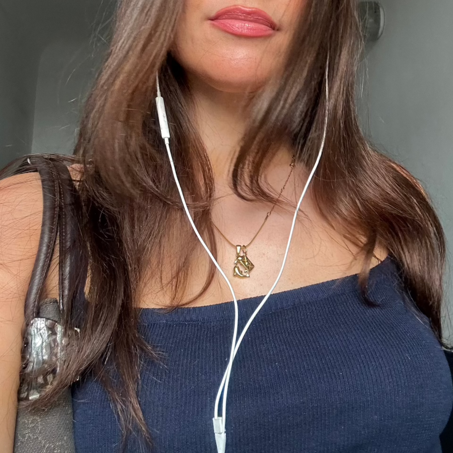 dancing dolphin and love letter charm worn on woman with blue top