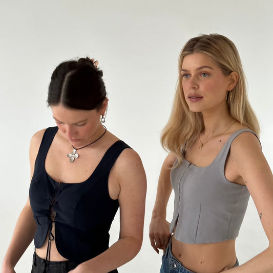 Lulu Hoops und Silberring Halskette getragen von zwei Mädchen vor weißer Wand