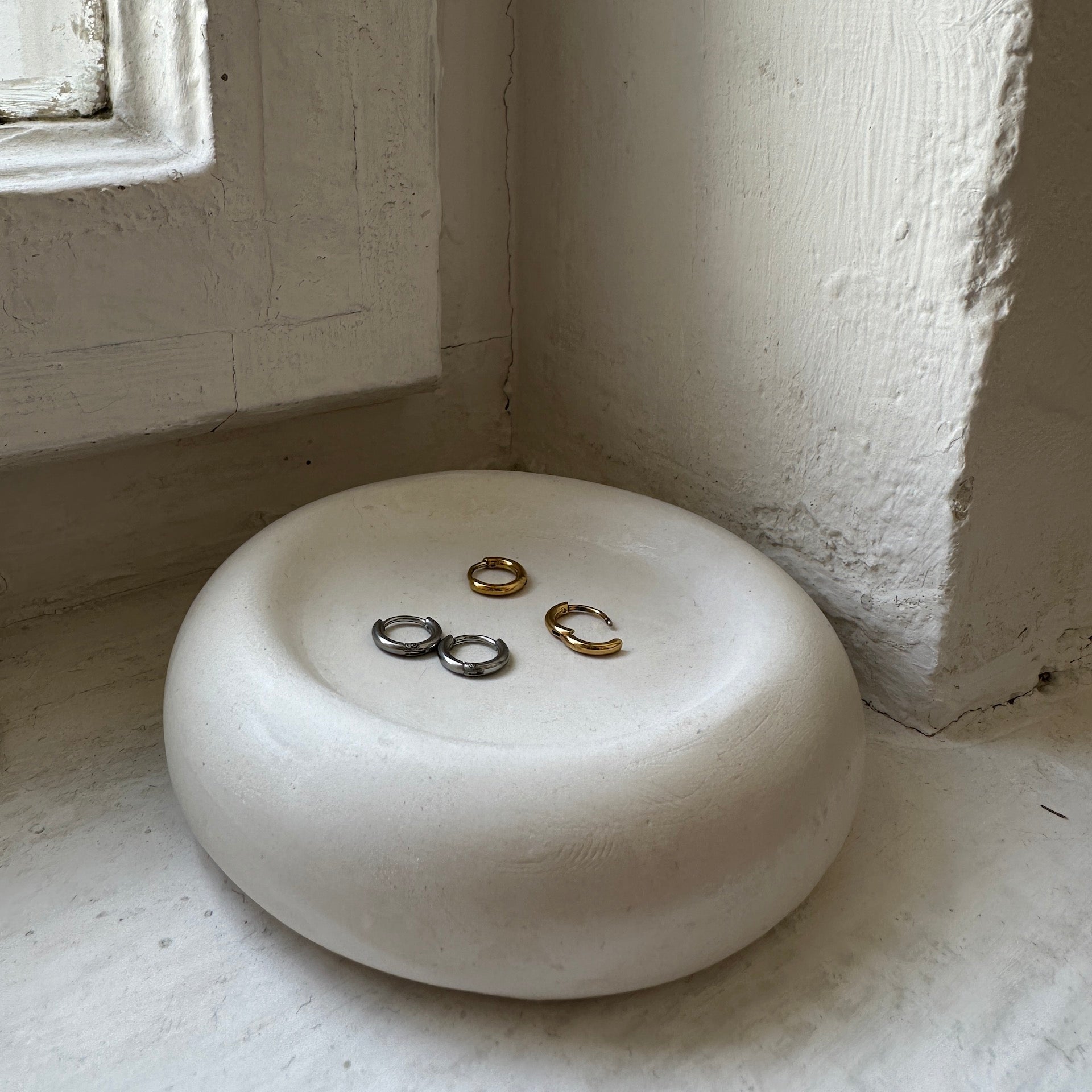 Mini Creolen in gold und silber in weißer Keramikschale