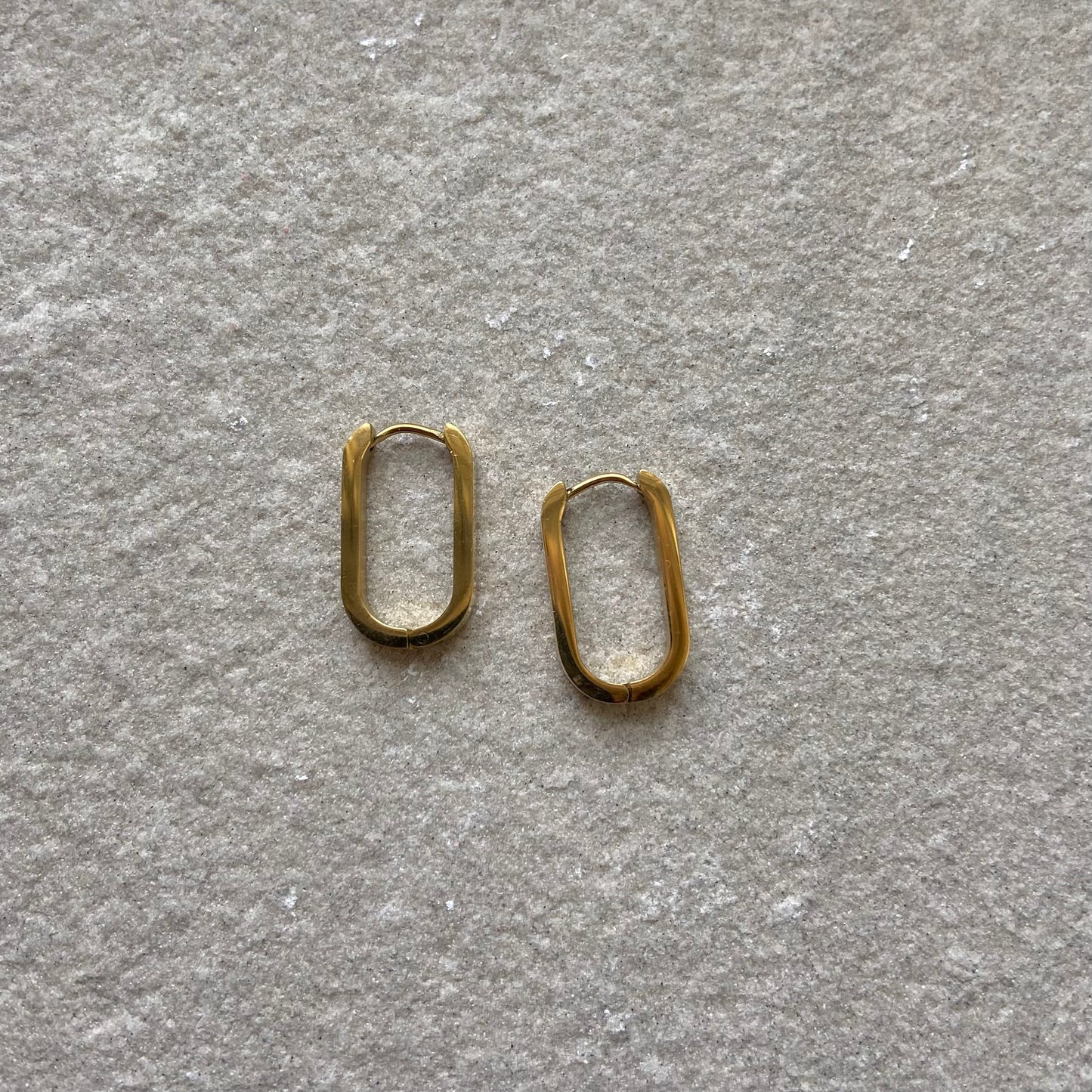 Oval Hoops Creolen Gold in gold auf weißer Steinplatte