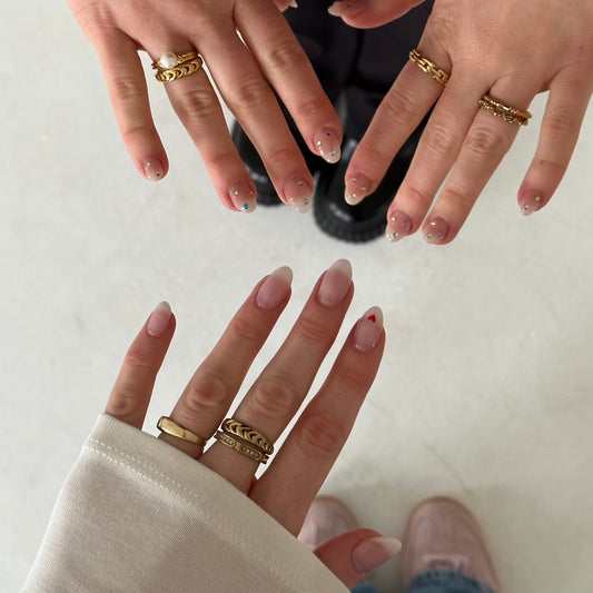 Ronny Ring und weitere Ringe getragen von drei Händen vor weiße Boden