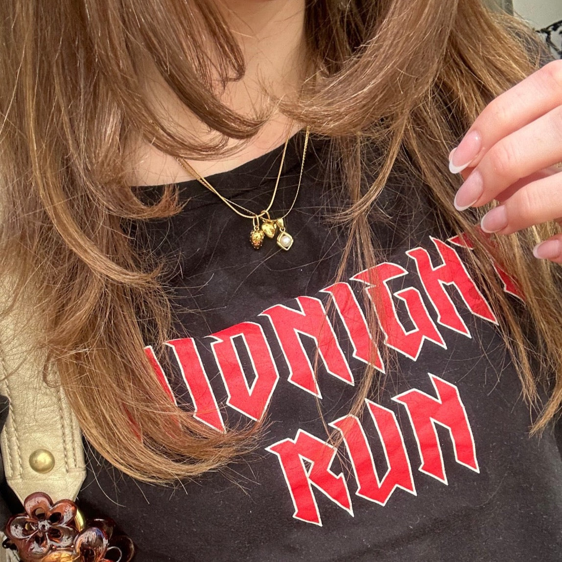 three necklaces worn on woman close up with black shirt