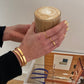 Golden Bracelet goldener Armreif am Handgelenk einer Frau, die einen Kaffee hält