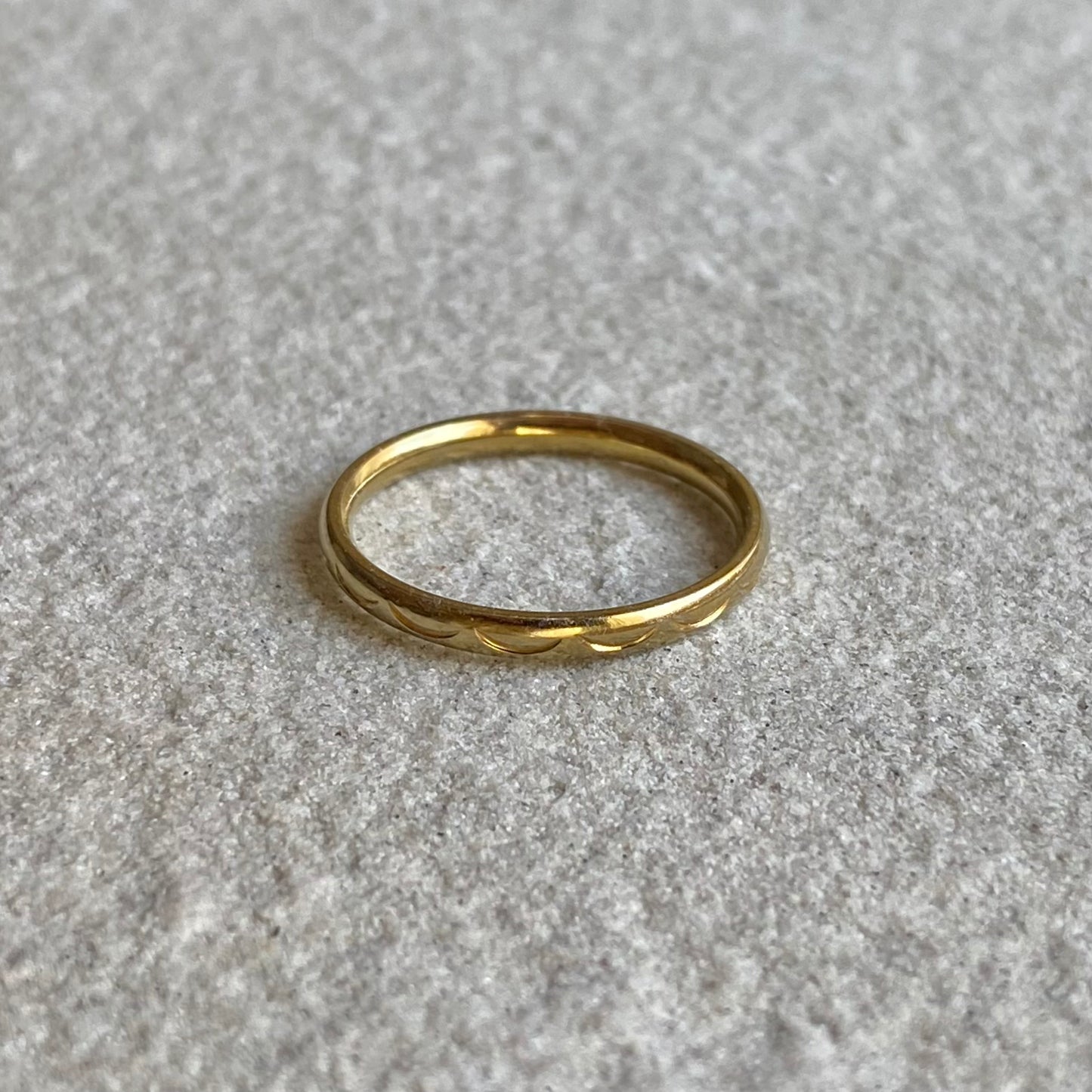 Halbmond Ring in gold auf weißer Steinplatte