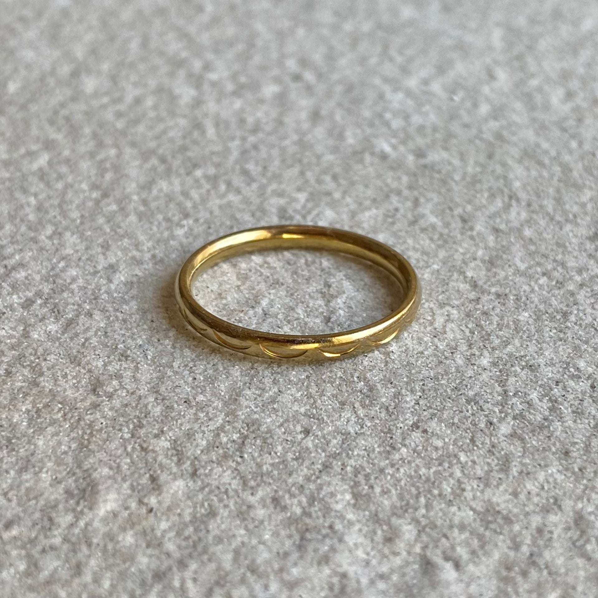 Halbmond Ring in gold auf weißer Steinplatte