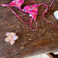 Heart of Gold Kette mit Herz auf Holztisch mit anderen Ketten, Ringen, Ohrringen und einem pinken Bikini