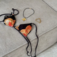 bikini laying om sofa with flower necklace and golden bracelet picture taken from above 