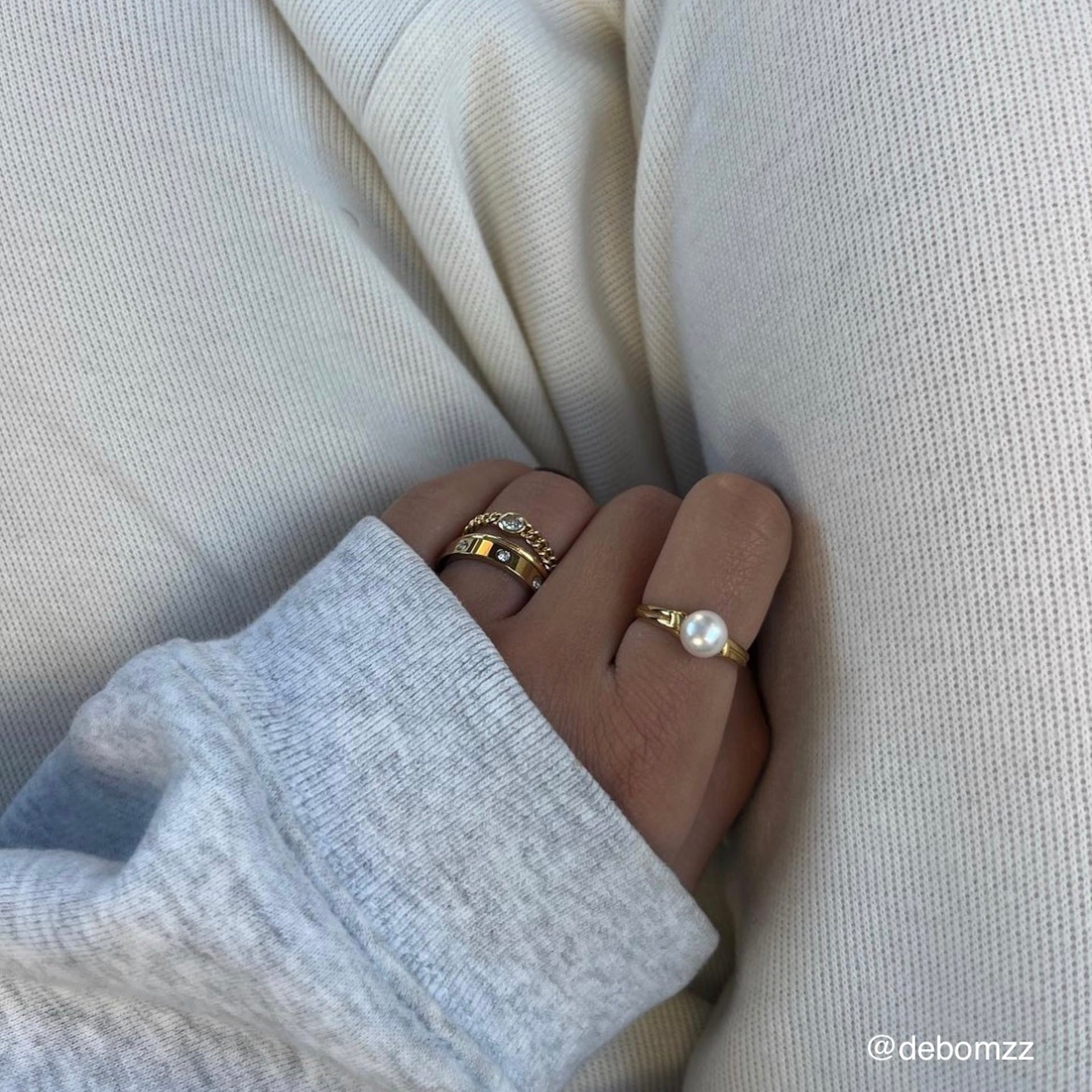 Goldener Ring mit Süßwasserperle getragen an Hand von Frau