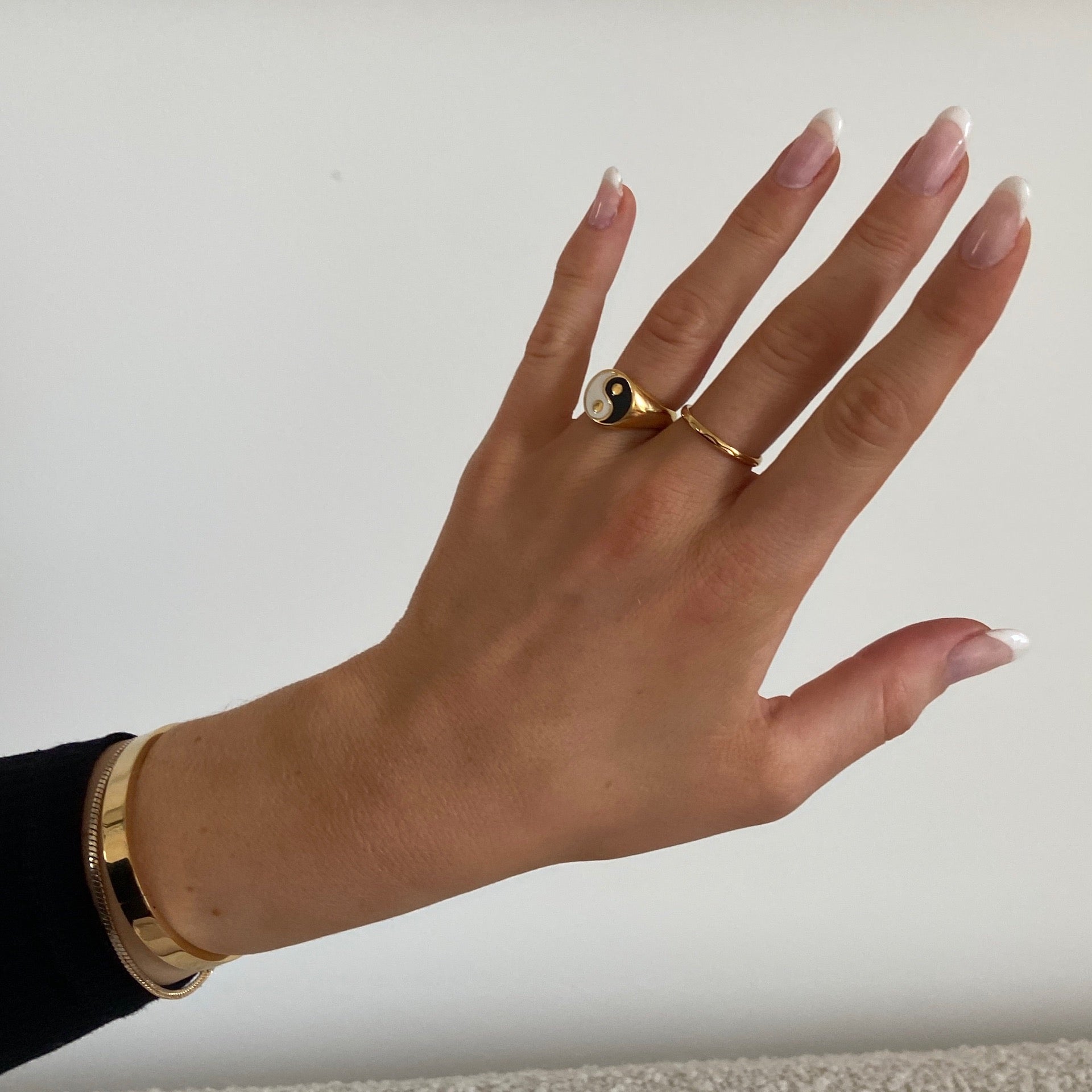Yin Yang Ring in gold getragen am Ringfinger an Hand von Frau