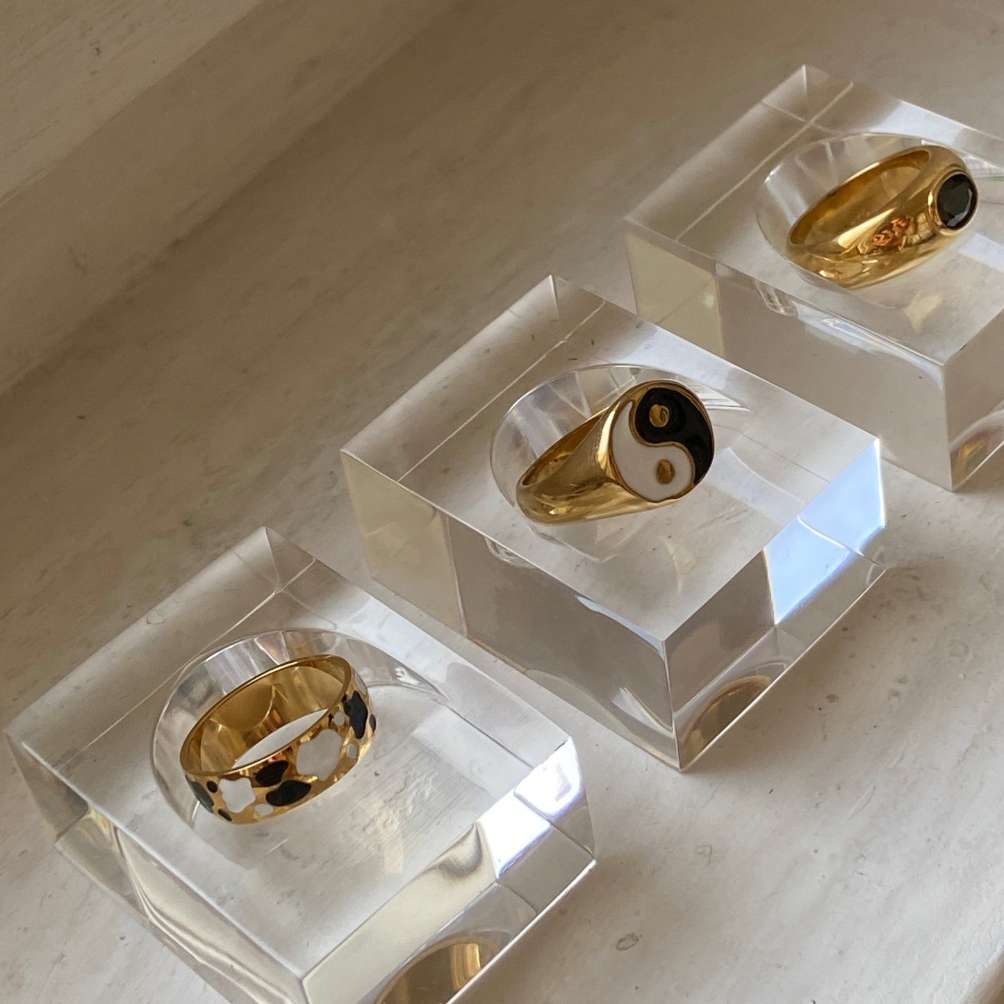 Yin Yang Ring in gold auf durchsichtigem Ringständer zusammen mit weiteren Ringen in gold