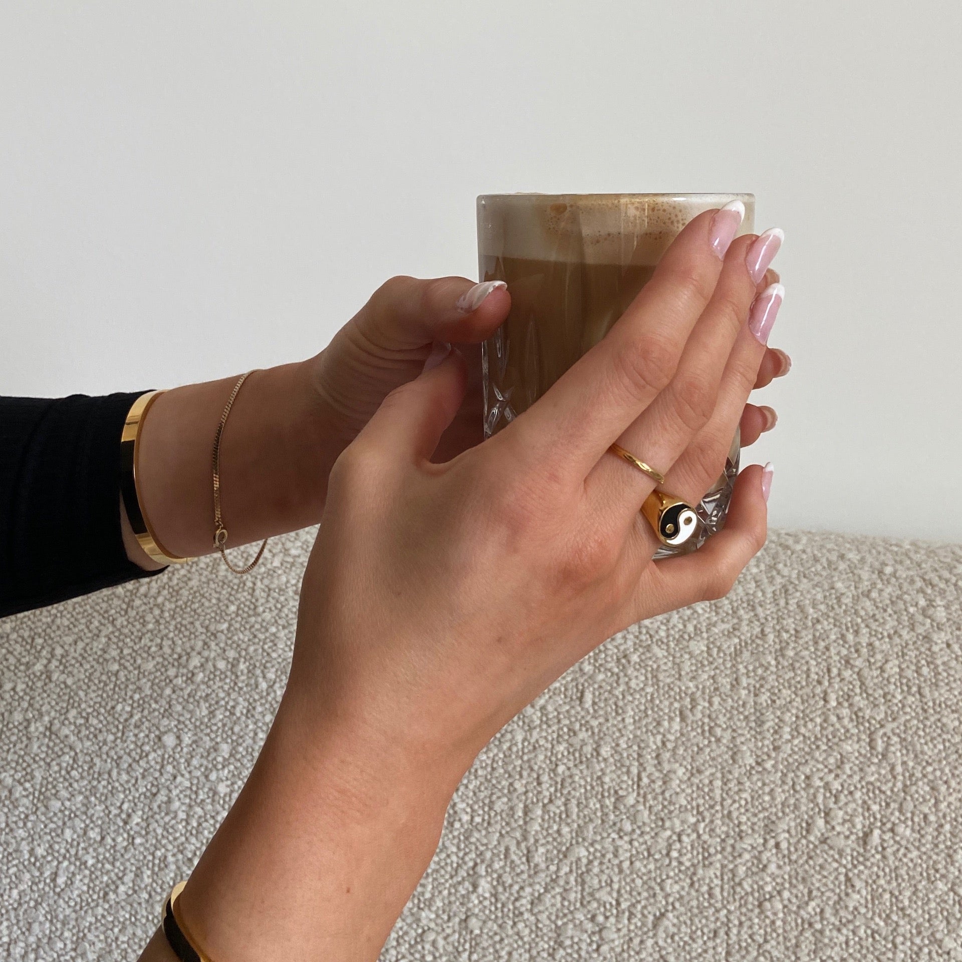Yin Yang Ring in gold getragen von Frau, die einen Kaffee in der Hand hält