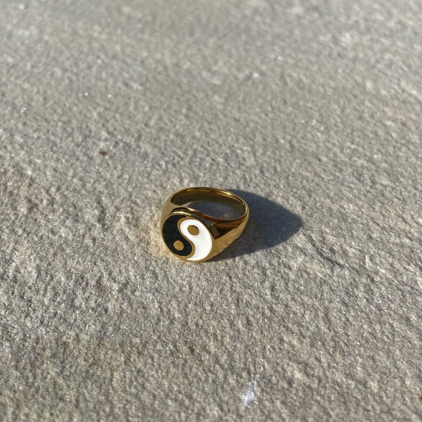 Yin Yang Ring in gold auf weißer Steinplatte